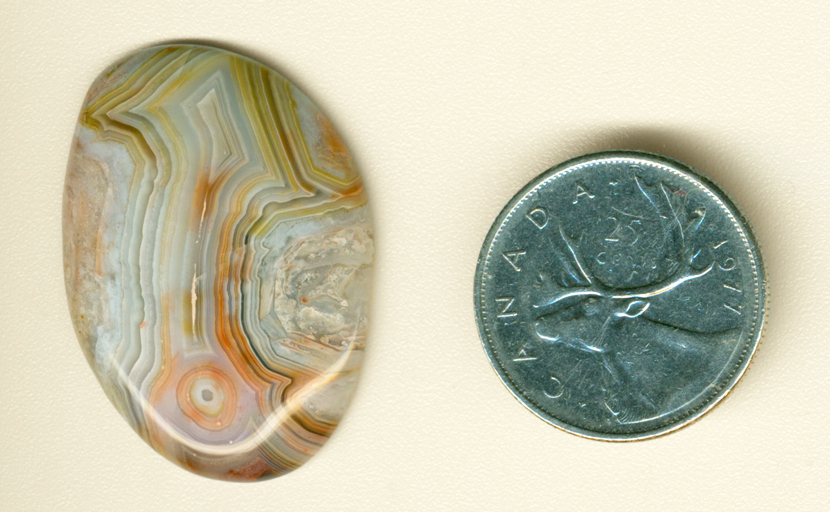 Pattern of an upward-pointing arrow in an orange, green, yellow, blue  and pink freeform Crazy Lace Agate from Mexico.