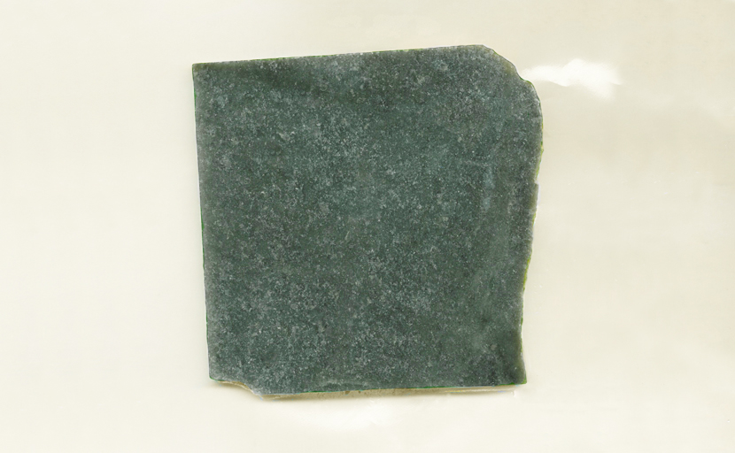 A square slab of Nephrite Jade from Wyoming, dark green mottled with lighter color.