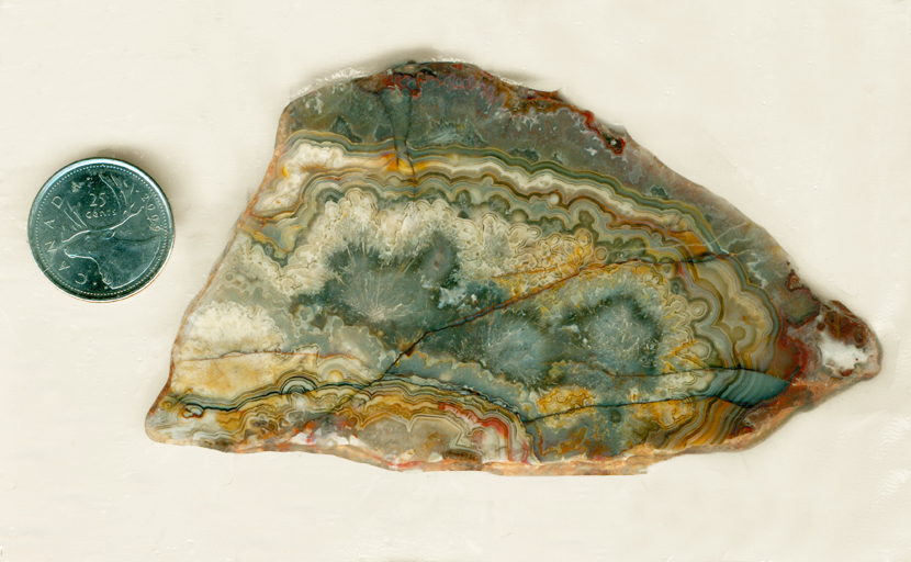 Central sagenite bursts with lacy green, red, pink and blue on the outside, in a slab of Sagenite Lace Agate from Mexico.