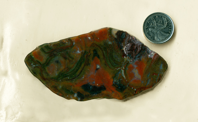 Red and green Christmas Flame Agate from Mexico, with curving stripes running through it.