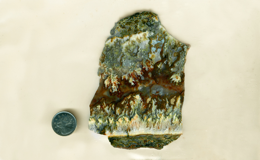 Slab of Linda Marie Agate from Oregon, with blue, green and yellow plumes rising and falling through an orange and blue background.