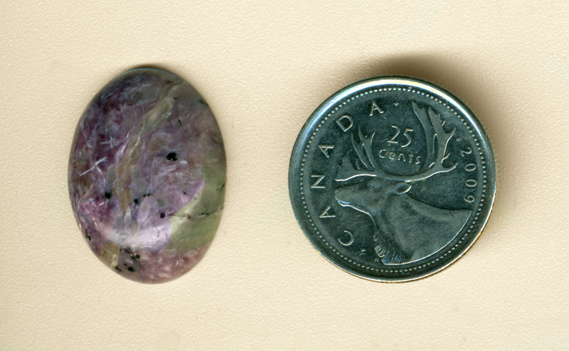 Cabochon of Charoite from Siberia, full of chatoyant purple fibres with dark and light areas.