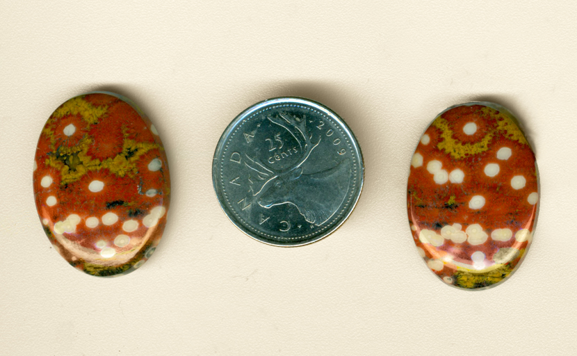Two matching polished cabochons of red and green Guadalupe Jasper, with white polka dots.