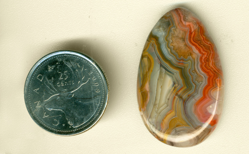 Orange, blue and yellow fortification patterns in a teardrop-shaped polished Crazy Lace Agate from Mexico.