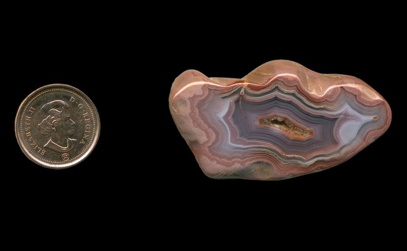 A polished freeform Fortification Agate from Mexico, with successive layers of blue, pink and purple in a deep fortification pattern