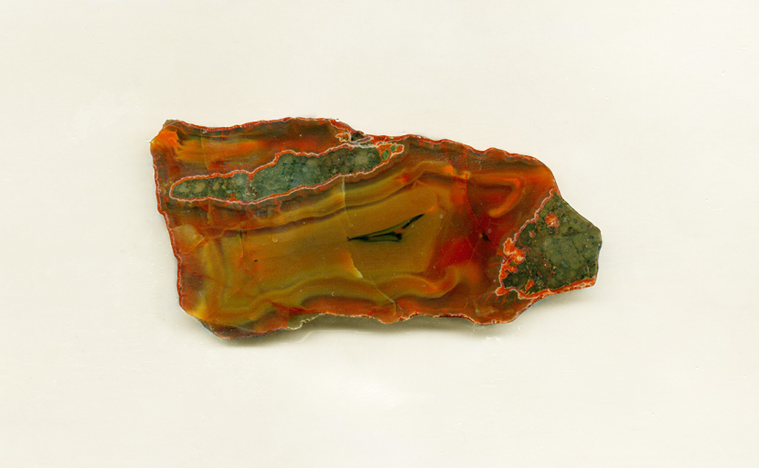 A slab of Condor Agate from Patagonia, with orange and yellow patterns and traces of green matrix.