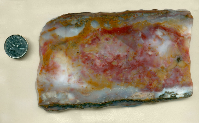 A slab of Vaquilla Agate from Mexico, with a veil of red and yellow colors on a pale blue background.