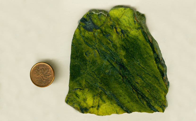 A slab of Pistachio Serpentine from Mexico, with bright yellowish green material and darker green stripes and blotches.