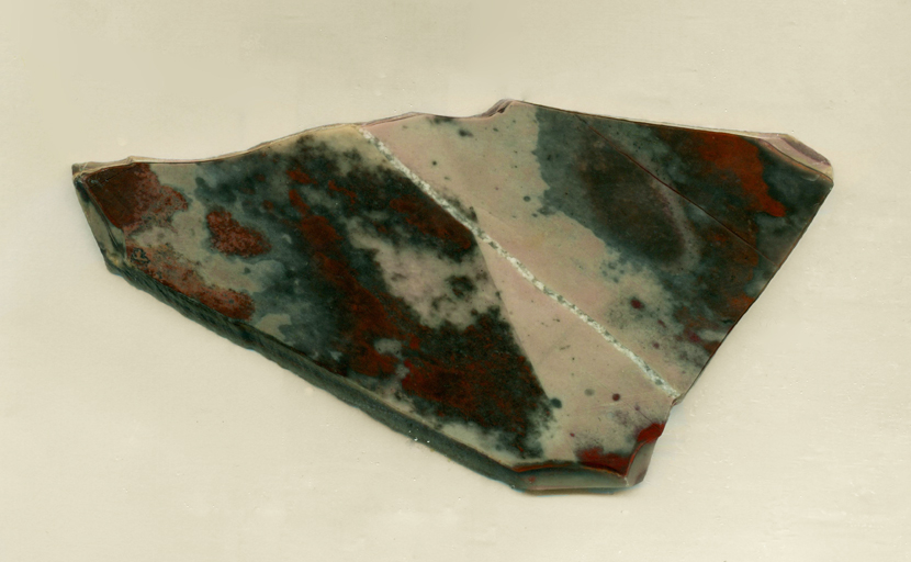 Earthy reds and brown mottled patterns on a triangular Jaspalite slab from Africa