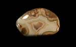A freeform piece of Fairburn Agate from Nebraska or South Dakota, creamy, yellow and red, with a central fortification pattern and bubble features around the edges.