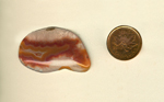 Freeform polished Coyamito Agate cabochon, clear with a red and purple covered yellow fortification in the center.