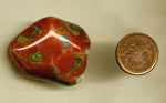 Freeform, polished tumbled Fairburn Agate from Nebraska or South Dakota, with white crystals covering the back and red and blue patterns all over its face.
